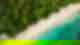 Aerial shot of secluded white sand with teal ocean and lush jungle with palm trees