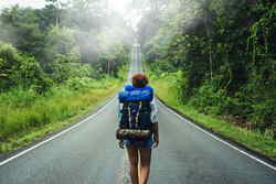 Backpacker in Asia walking along road