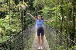 Traveller on suspension bridge in green rainforest with lots of trees, Costa Rica