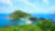 Emerald island hills connected with bright blue waters in between, lowland island in between