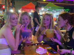 Girls drinking at bar on Thai Adventure tour