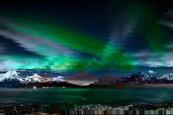 Northern lights in Norway with mountains and Artic sea