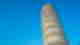 Clear blue sky with leaning tower in the sky with columns built around it