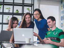 Young professionals around laptop in office