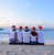 Backpackers sat on beach with christmas hats on