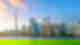 City skyline from lake with lots of modern skyscrapers and some green shrubbery with light sunset haze in blue sky