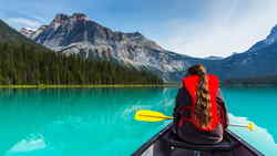 Traveller kayaking on lake in Canada