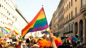 People with rainbow flags celebrating Pride in street in Europe