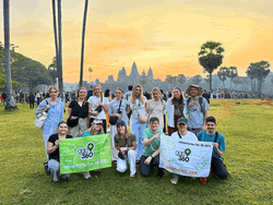 Group Travellers holding flag at Cambodia Angkor Wat at sunrise