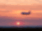 Plane flying over sunset sky